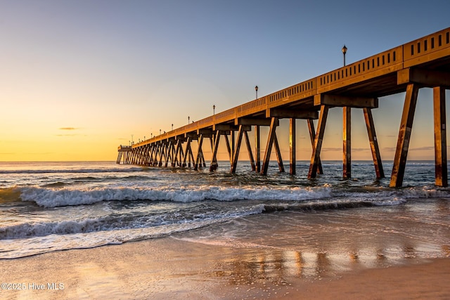 dock area featuring a view of the beach, a pier, and a water view