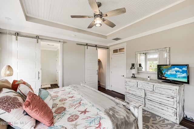 117 NW 2nd St, Oak Island, NC 28465 - bedroom featuring a tray ceiling, a barn door, visible vents, and dark wood finished floors