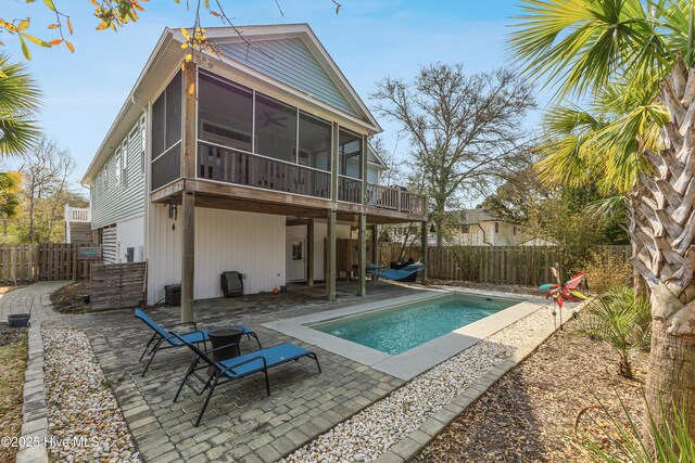 117 NW 2nd St, Oak Island, NC 28465 - rear view of house featuring a sunroom, a patio, a fenced backyard, and a fenced in pool