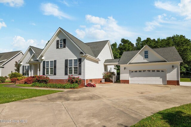 view of front of property with a garage, a front lawn, roof with shingles, and concrete driveway