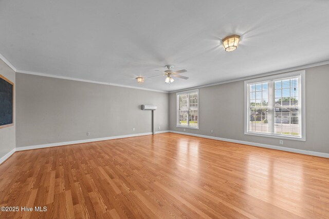 spare room featuring baseboards, ornamental molding, light wood finished floors, and a ceiling fan