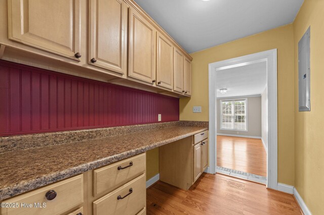 laundry room featuring light wood-style floors, baseboards, and electric panel