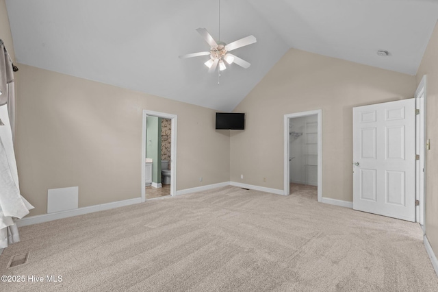 unfurnished bedroom with visible vents, high vaulted ceiling, a closet, a spacious closet, and light carpet
