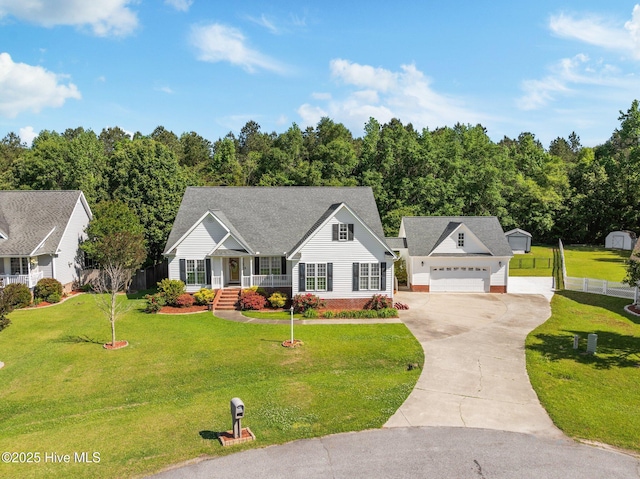 view of front of house with a front lawn, fence, covered porch, driveway, and an outbuilding