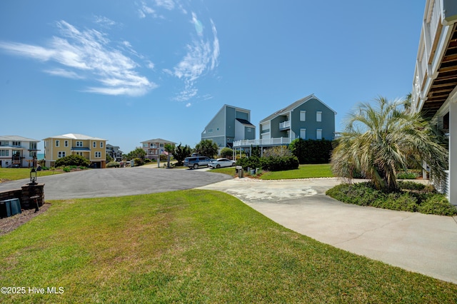 view of yard featuring driveway and a residential view