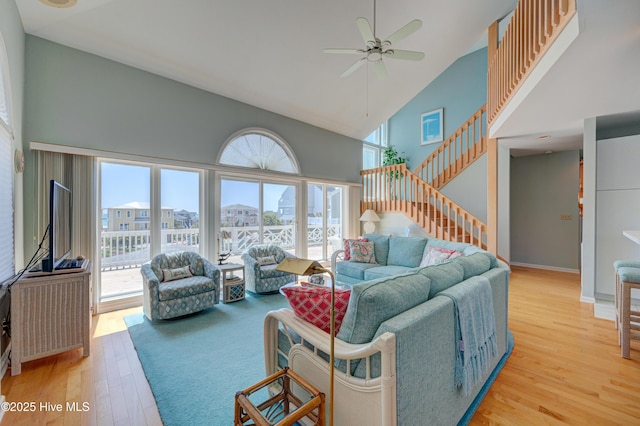 living room featuring light wood-type flooring, plenty of natural light, high vaulted ceiling, and a ceiling fan