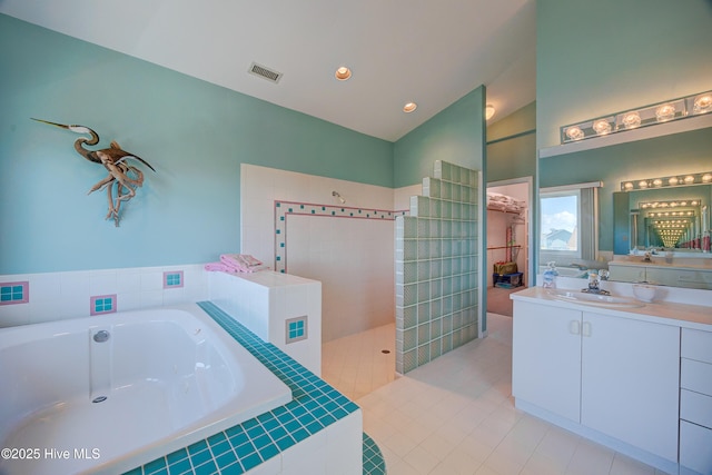 full bathroom with vanity, a bath, a walk in shower, visible vents, and lofted ceiling