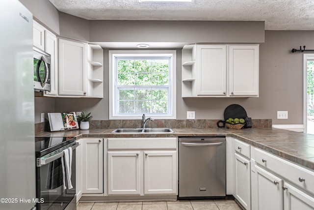 4915 Beulah Hill Church Rd, West End, NC 27376 - kitchen featuring stainless steel appliances, a sink, open shelves, a textured ceiling, and white cabinets