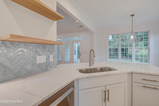 226 Bayfield Dr, Wilmington, NC 28411 - kitchen featuring white cabinets, pendant lighting, light stone countertops, tasteful backsplash, and plenty of natural light