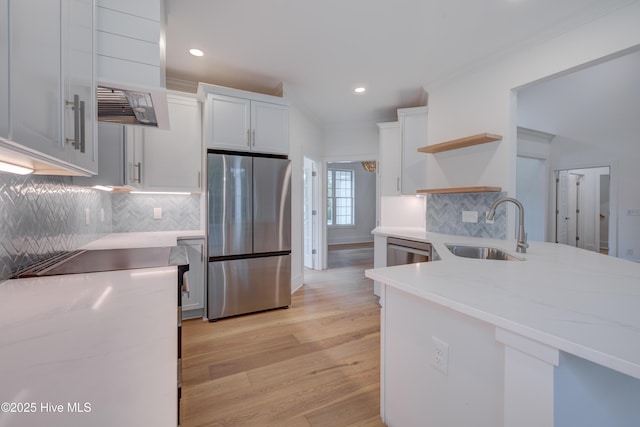 226 Bayfield Dr, Wilmington, NC 28411 - kitchen with stainless steel appliances, open shelves, light wood-style floors, white cabinetry, and tasteful backsplash