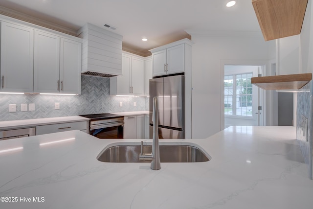 226 Bayfield Dr, Wilmington, NC 28411 - kitchen with stainless steel appliances, premium range hood, backsplash, white cabinetry, and recessed lighting