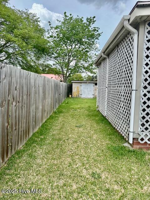 view of yard with a shed, an outdoor structure, and fence