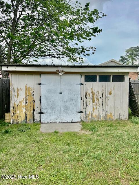 garage featuring a storage shed and fence