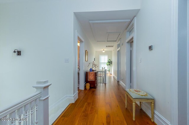 411 Queen St, New Bern, NC 28560 - corridor with baseboards, an upstairs landing, wood finished floors, and attic access