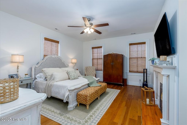 411 Queen St, New Bern, NC 28560 - bedroom featuring visible vents, a ceiling fan, wood finished floors, and a fireplace