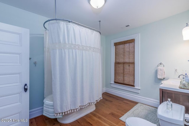 411 Queen St, New Bern, NC 28560 - full bath with baseboards, a shower with shower curtain, wood finished floors, and toilet