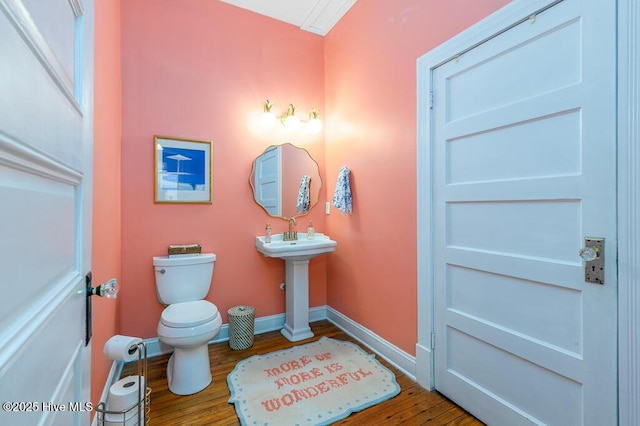 411 Queen St, New Bern, NC 28560 - bathroom featuring toilet, baseboards, and wood finished floors