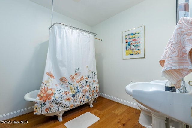 411 Queen St, New Bern, NC 28560 - bathroom with a shower with shower curtain, baseboards, a sink, and wood finished floors