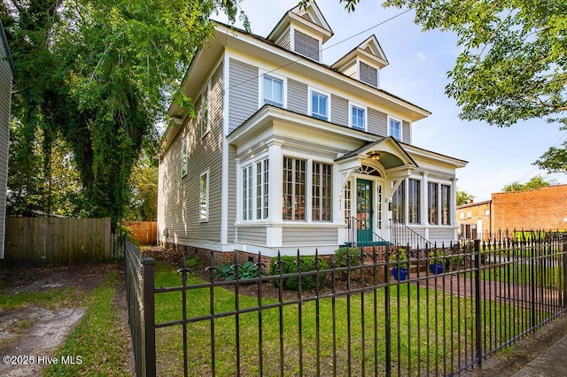 411 Queen St, New Bern, NC 28560 - american foursquare style home featuring a fenced front yard, a sunroom, and a front yard