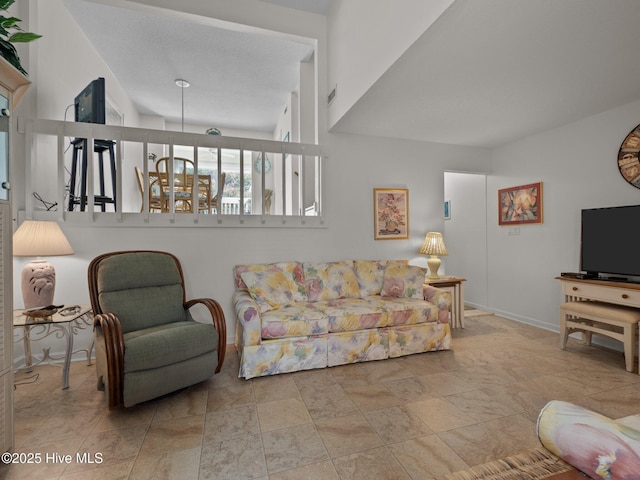 living area featuring baseboards and stone finish floor