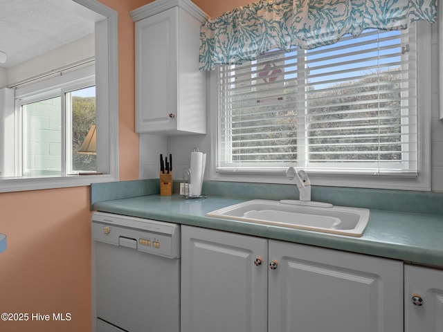 kitchen featuring white cabinets, a healthy amount of sunlight, dishwasher, and a sink
