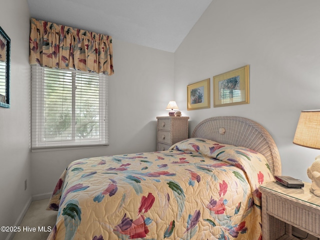 bedroom featuring carpet flooring, lofted ceiling, and baseboards