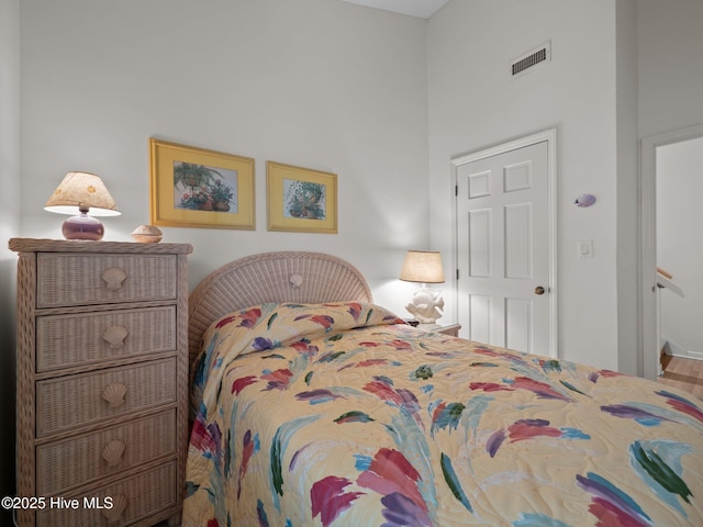 bedroom with a towering ceiling and visible vents