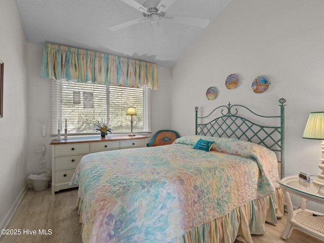 bedroom with light wood-style flooring, a ceiling fan, vaulted ceiling, and baseboards