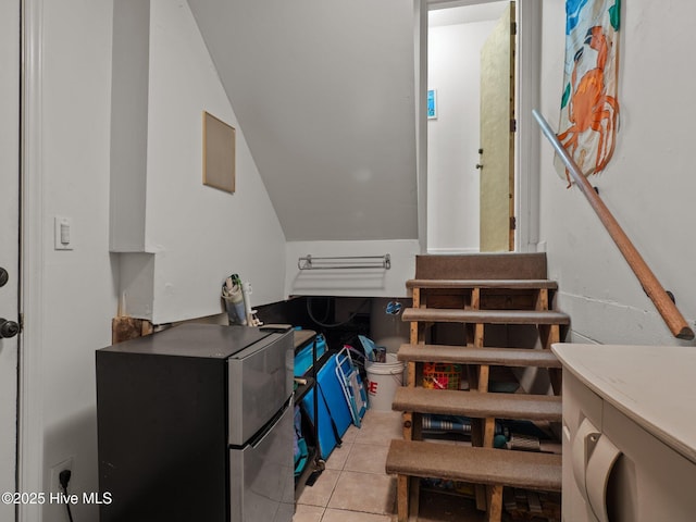 stairway with tile patterned flooring and lofted ceiling