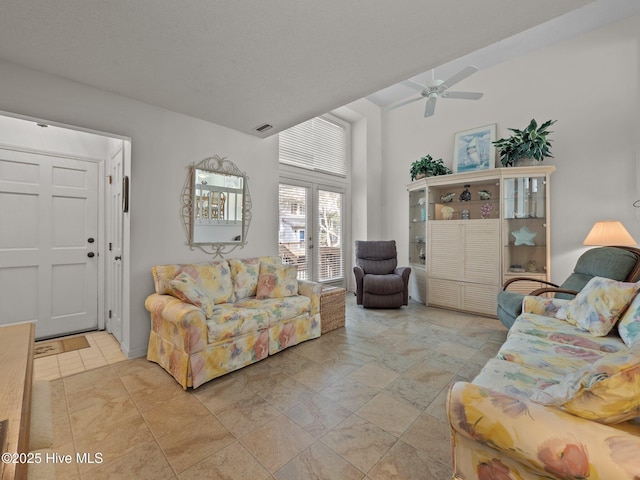 living area with ceiling fan and visible vents