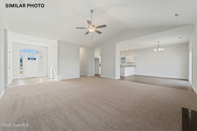 608 Indigo Johnston Dr, Jacksonville, NC 28546 - unfurnished living room with visible vents, baseboards, ceiling fan with notable chandelier, light colored carpet, and lofted ceiling