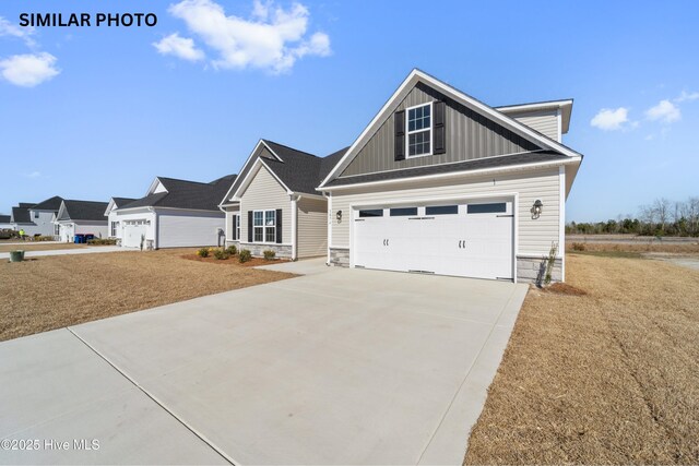 608 Indigo Johnston Dr, Jacksonville, NC 28546 - craftsman house with concrete driveway, board and batten siding, and stone siding