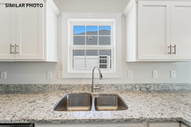 608 Indigo Johnston Dr, Jacksonville, NC 28546 - kitchen with a sink, white cabinetry, and light stone counters