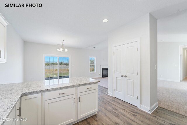 608 Indigo Johnston Dr, Jacksonville, NC 28546 - kitchen featuring light wood-type flooring, baseboards, a chandelier, open floor plan, and white cabinetry