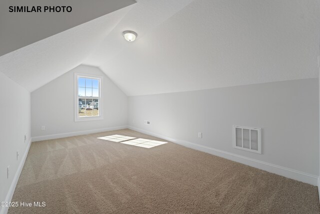 608 Indigo Johnston Dr, Jacksonville, NC 28546 - additional living space featuring visible vents, baseboards, light colored carpet, and lofted ceiling