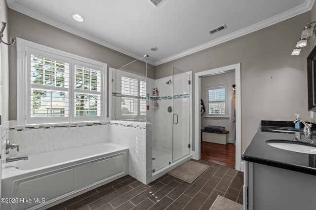 281 Whichard Ln, Chocowinity, NC 27817 - bathroom featuring a bath, a stall shower, ornamental molding, double vanity, and wood finish floors