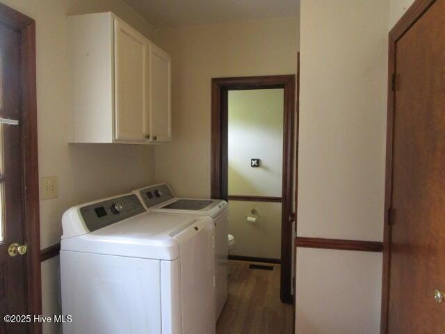laundry room with washer and dryer, wood finished floors, and cabinet space
