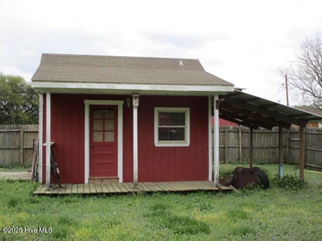 view of outdoor structure featuring an outbuilding and fence