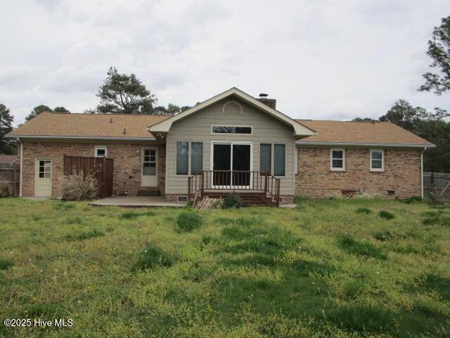 back of house with a lawn, a patio, crawl space, and a chimney