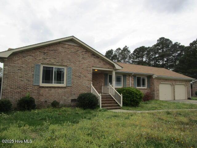 ranch-style home featuring brick siding, crawl space, a front lawn, and a garage