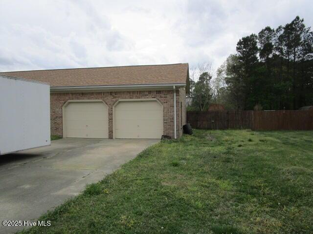 garage featuring fence and driveway