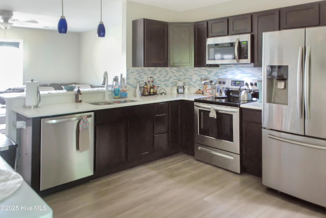 314 Nugget Trl, Elizabeth City, NC 27909 - kitchen with stainless steel appliances, a sink, light countertops, dark brown cabinetry, and light wood finished floors