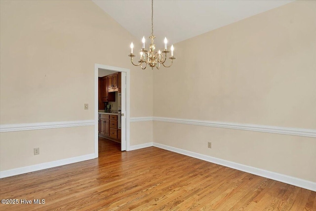 17 Windsong Pl, Whispering Pines, NC 28327 - spare room featuring a chandelier, wood finished floors, and vaulted ceiling