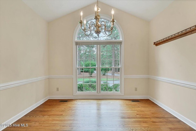 17 Windsong Pl, Whispering Pines, NC 28327 - unfurnished dining area featuring a chandelier, wood finished floors, and vaulted ceiling