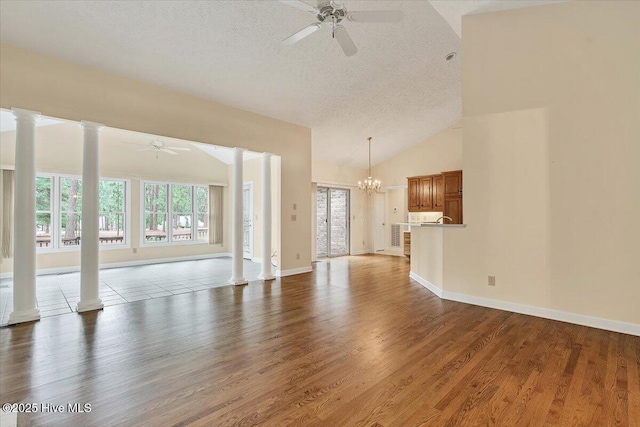 17 Windsong Pl, Whispering Pines, NC 28327 - unfurnished living room featuring ceiling fan, ornate columns, a textured ceiling, plenty of natural light, and high vaulted ceiling