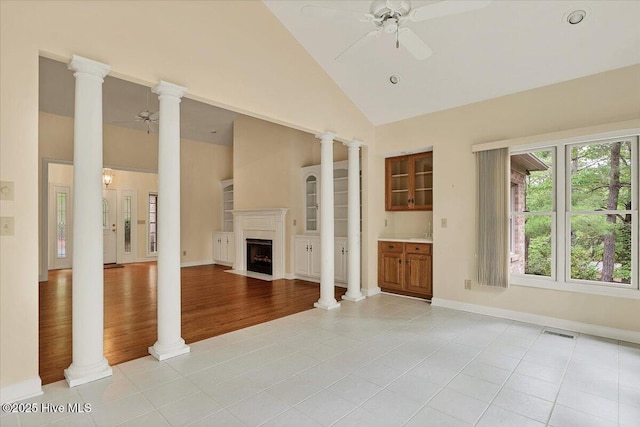 17 Windsong Pl, Whispering Pines, NC 28327 - unfurnished living room with a ceiling fan, light tile patterned flooring, high vaulted ceiling, and a fireplace with flush hearth