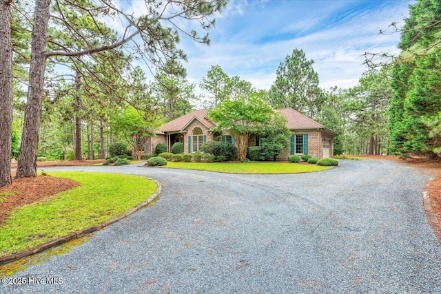 17 Windsong Pl, Whispering Pines, NC 28327 - ranch-style house featuring curved driveway and a front lawn