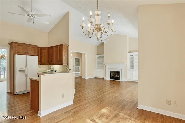 17 Windsong Pl, Whispering Pines, NC 28327 - kitchen featuring white refrigerator with ice dispenser, high vaulted ceiling, a chandelier, light wood-type flooring, and brown cabinetry