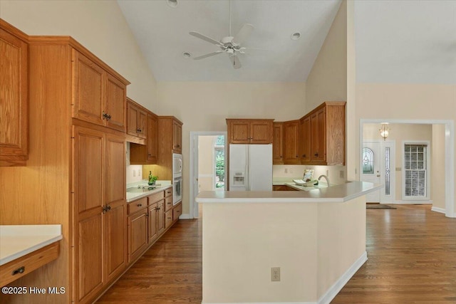 17 Windsong Pl, Whispering Pines, NC 28327 - kitchen featuring white fridge with ice dispenser, high vaulted ceiling, ceiling fan, wood finished floors, and brown cabinets
