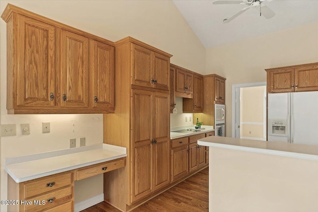 17 Windsong Pl, Whispering Pines, NC 28327 - kitchen featuring white appliances, built in study area, vaulted ceiling, brown cabinetry, and a ceiling fan